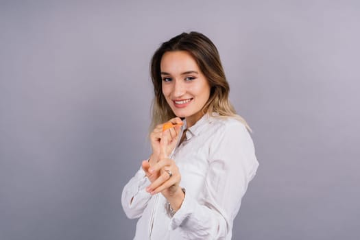 Portrait of beautiful woman with ballon in hands on grey background in studio