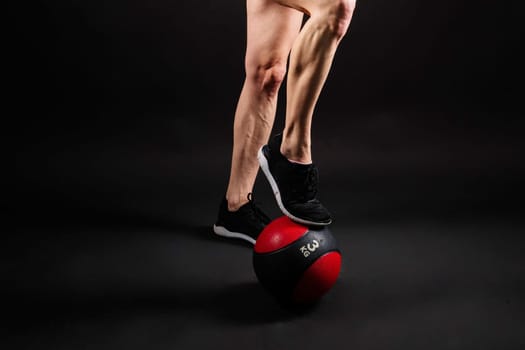 Portrait of a fitness happy fit woman standing holding a medicine ball. Copy Free space for text. Slim caucasian cross fit woman with fitness ball stand in gym, look. Plain light wall background