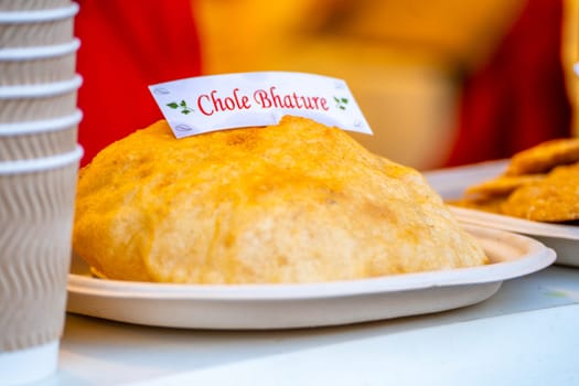 Plate with food and tag of chole bhature showing the puffed flat bread popularly eaten with chickpeas all across India