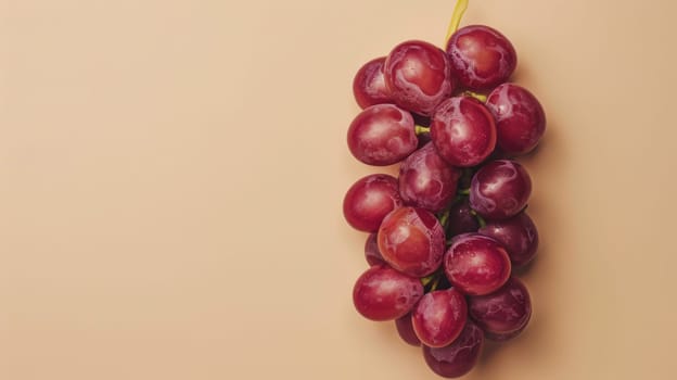 Bunch of red grapes on a beige background, minimalistic fruit concept.