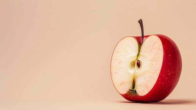 Half of a red apple on a beige background, close-up with seeds visible. Healthy eating and fresh fruit concept.