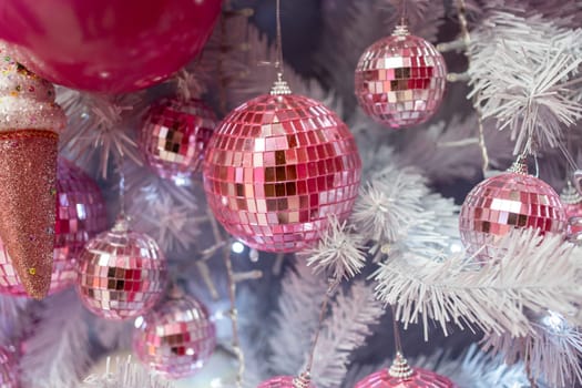 Closeup of Christmas tree adorned with pink shiny baubles and decorations. Embracing the Christmas holiday concept with beautiful and festive Christmas tree.