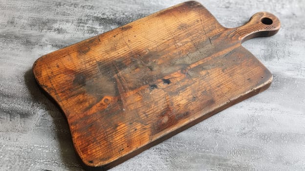 Rustic wooden cutting board on gray textured background, culinary concept.