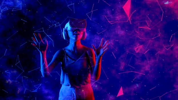 Excited smiling Asian woman looking around through VR metaverse with pointing on blue neon digital universe starry zodiac virtual space fantastic exploration nebula vibrant meta world. Hallucination.
