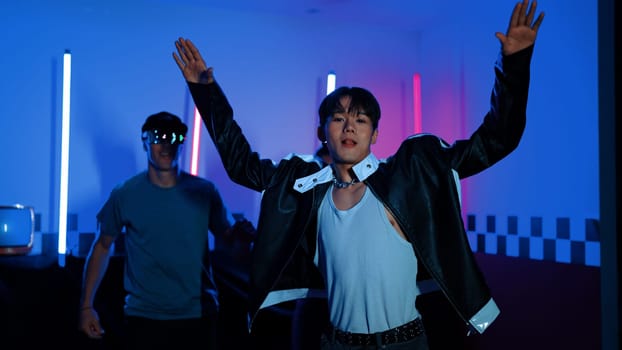 Skilled break dancer dancing in front of camera while diverse friend moving to pop or hip hop music behind. Attractive performer team taking turn to perform energetic movement at camera. Regalement.