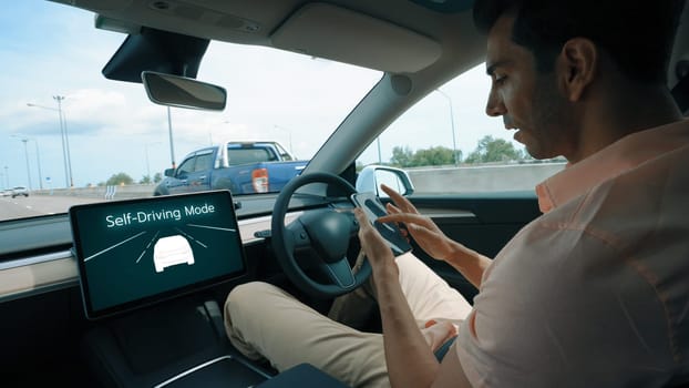 Self driving car or autonomous vehicle travel on speed highway with driverless system and autopilot mode allowing man driver relax and focus on smartphone without compromising safety. Perpetual