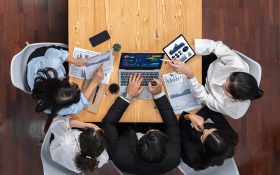 Panorama top view diverse group of business analyst team analyzing financial data report paper on meeting table. Chart and graph dashboard by business intelligence analysis. Meticulous