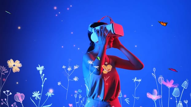 Beautiful Asian woman with VR to metaverse interacting virtual neon flower playing with butterfly flying new neon blossom blue background 3D pollen graphic floating meta garden world. Hallucination.