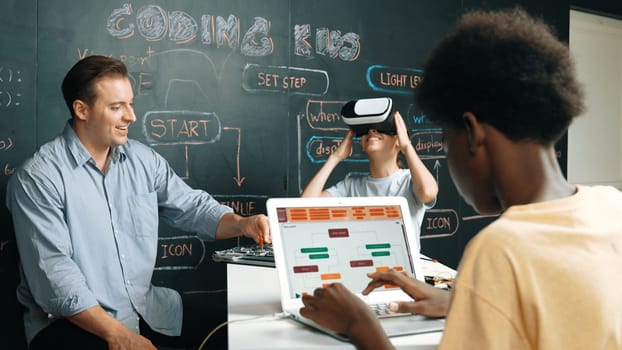 Girl wear VR glass and learning metaverse while instructor using electronic board. African student writing system while receive advice from teacher at table with electronic equipment. Edification.