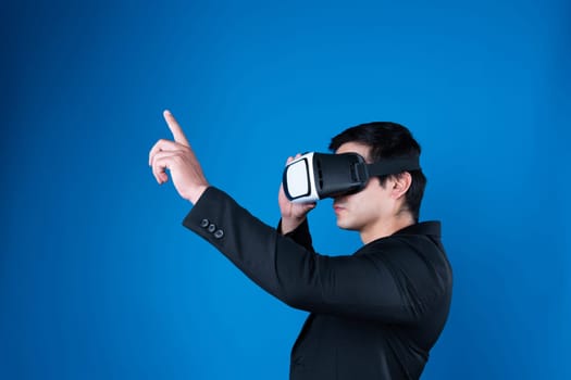 Profile businessman wearing VR headset looking to connect metaverse pointing to choose interesting data isolated blue background futuristic analytics communication tech virtual reality. Contrivance.