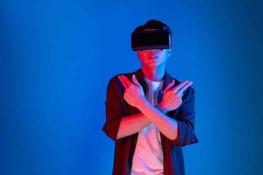 Smart gamer wearing VR turning to metaverse world playing gun shooting hunter isolated blue neon light connected to victory animal hunting futuristic technology hologram virtual reality. Contrivance.
