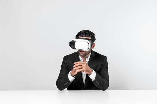 Professional businessman wearing visual reality glasses and suit while sitting. Smart caucasian project manager looking at data analysis by using VR headset. Innovation technology concept. Deviation.