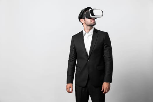 Skilled project manager with VR glasses standing and looking around. Caucasian businessman connecting with metaverse and virtual reality world while wearing suit. Innovation technology. Deviation.