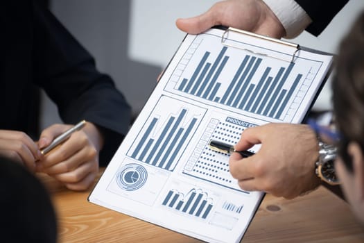 Diverse group of business analyst team analyzing financial data report paper on office table. Chart and graph dashboard by business intelligence analysis for strategic marketing planning Meticulous