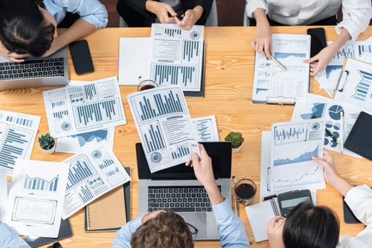 Panorama top view diverse group of business analyst team analyzing financial data report paper on meeting table. Chart and graph dashboard by business intelligence analysis. Meticulous