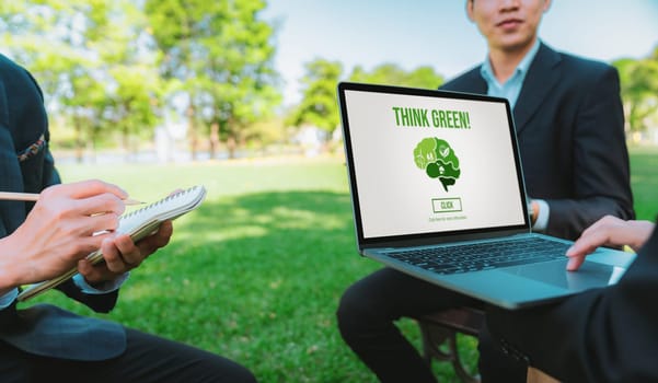 Group of asian business people planning on environmentally friendly development plan on laptop screen and sustainable technology project for greener future, outdoor eco office at natural park. Gyre