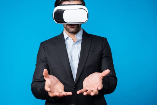 Smart business man with suit holding something while VR goggle to connect metaverse. Professional project manager looking at hologram by using visual reality headset. Technology innovation. Deviation.