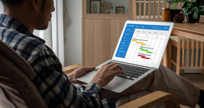 Project planning software for modish business project management on the computer screen showing timeline chart of the team project