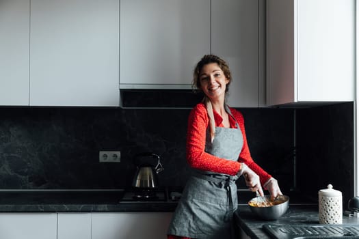 a woman cook cooks food in a bowl in the kitchen