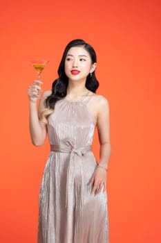 Woman, portrait smile and glass champagne standing in stylish fashion isolated on red background