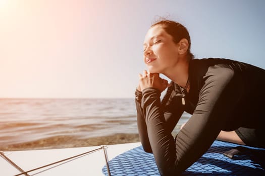 Woman sup yoga. Middle age sporty woman practising yoga pilates on paddle sup surfboard. Female stretching doing workout on sea water. Modern individual hipster outdoor summer sport activity