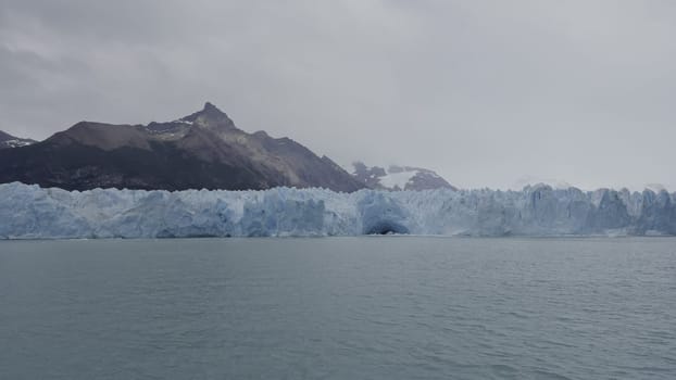 Observing the grandeur of glaciers from a boat, admiring their monumental ice formations amidst pristine wilderness.