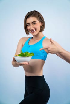 Full body length gaiety shot athletic and sporty young woman with healthy vegan food in standing posture on isolated background. Healthy active and body care by vegetarian lifestyle.