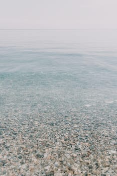 A calm body of water with a few rocks scattered throughout. The water appears to be clear and still, with no visible waves or ripples. The rocks are of various sizes