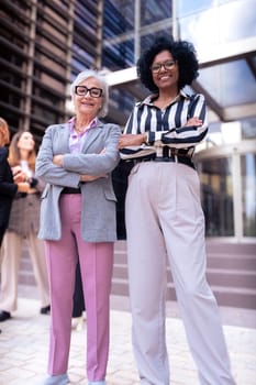 Happy businesswomen standing side by side with their arms crossed. Suitable for team, friendship and diversity concepts.