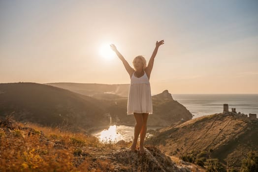 woman standing hill with her arms raised in the air, looking up at the sun. The scene is peaceful and serene, with the woman's expression conveying a sense of joy and happiness