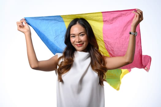 Confident young adult woman holding pansexual flag isolate white background. Lgbtq, human rights and equality concept.