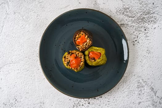 Stuffed green bell pepper and eggplant with olive oil on stone table