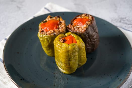 Stuffed green bell pepper and eggplant with olive oil on stone table