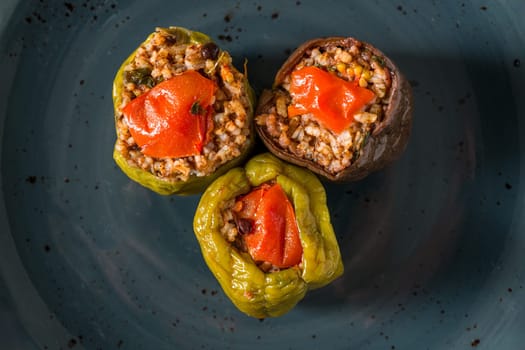 Stuffed green bell pepper and eggplant with olive oil on stone table