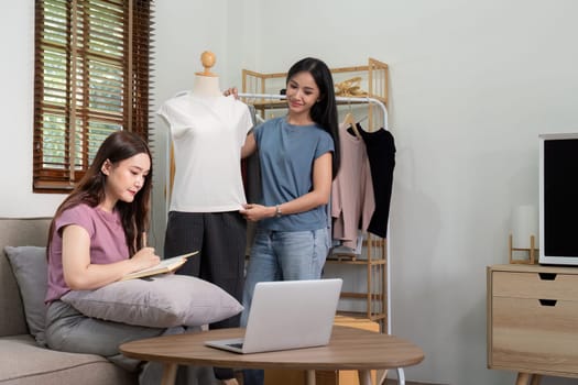 Lesbian couple working together on their online clothing business, showcasing teamwork and modern entrepreneurship in a cozy home setting.