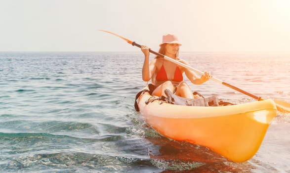 Happy smiling woman in kayak on ocean, paddling with wooden oar. Calm sea water and horizon in background