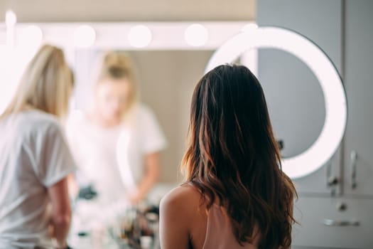 Makeup woman artist at work, professional in action with young model in beauty salon and creative classes