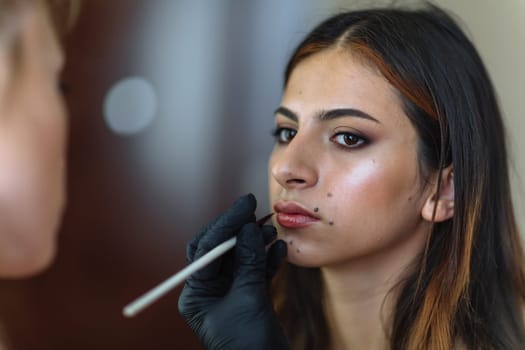 Makeup woman artist at work, professional in action with young model in beauty salon and creative classes