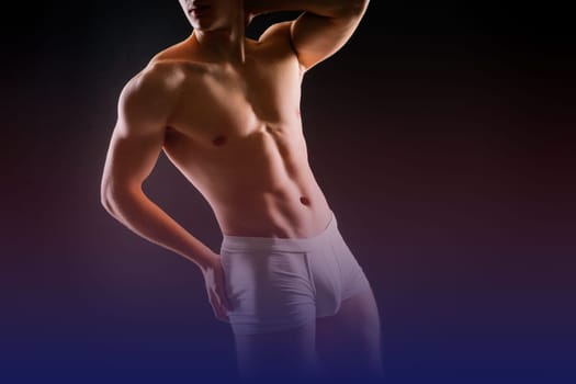 Man holds barbell weights, young adult strong male in a white briefs, studio shot. Sport and muscles.