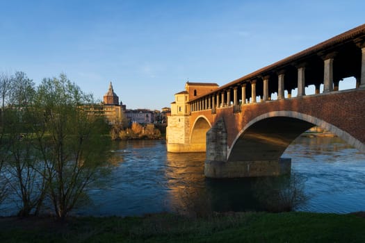 Nice view of Ponte Coperto (covered bridge) and Duomo di Pavia (Pavia Cathedral) in Pavia at sunny day, Lombardy, italy.