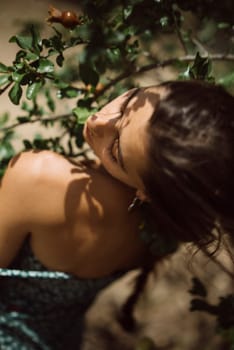 A serene capture of a woman interacting with nature, featuring a snail on a branch, viewed from above.