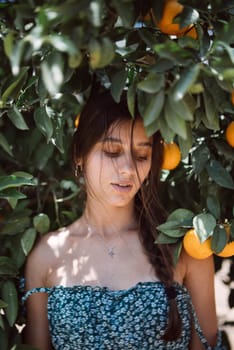 In a sunlit orchard, a serene moment captures a young woman standing among orange trees in a peaceful setting