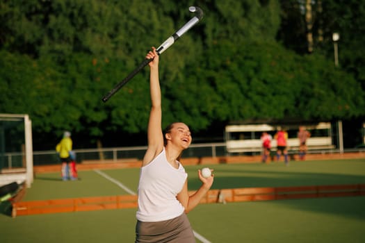 girl hockey player plays field hockey on a sunny day, female hockey player celebrates a goal scored, victory in a field hockey match, active sport for girls