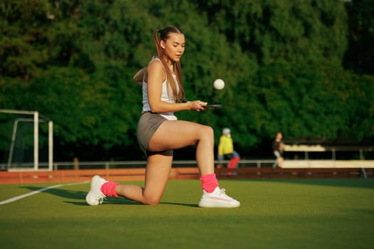 girl hockey player plays field hockey on a sunny day, female hockey player hits the ball with a stick, field hockey concept