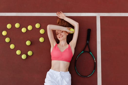 young woman tennis player lies on the tennis court, tennis balls in the shape of a heart, top view, tennis championship