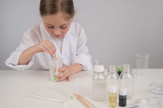 Caucasian girl doing chemical experiments on a white background