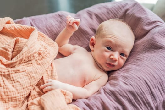 A newborn lies in his cozy cocoon on muslin swaddles. This serene moment captures the comfort and security of a newborn, highlighting the gentle care and nurturing environment.