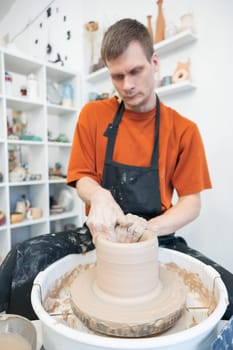 A potter working on a potter's wheel. Vertical photo