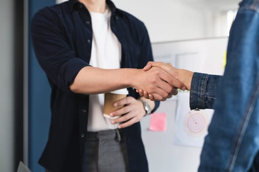 Two people shaking hands in a business setting. Concept of professionalism and trust between the two individuals