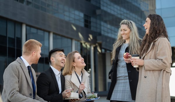 Multiracial business people enjoying a lunch break outdoor from office building.